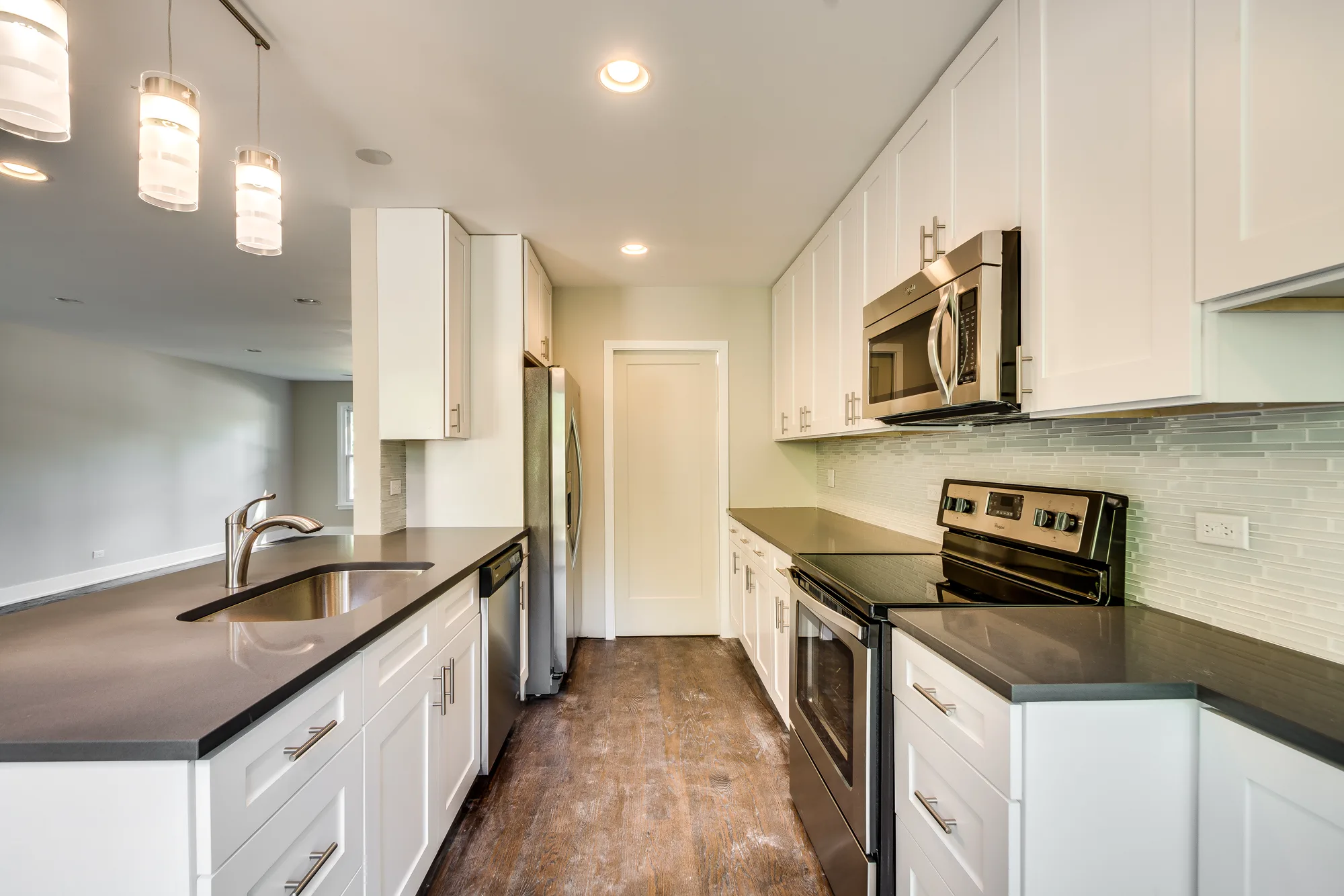 Galley kitchen with quartz countertops and hardwood floors